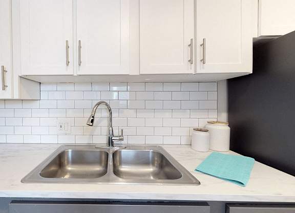 A kitchen with a white countertop and a black refrigerator.
