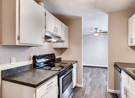 A kitchen with black countertops and white cabinets.