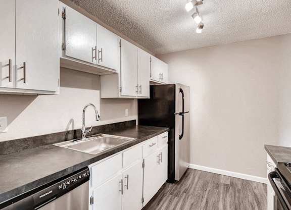 A kitchen with black appliances and white cabinets.