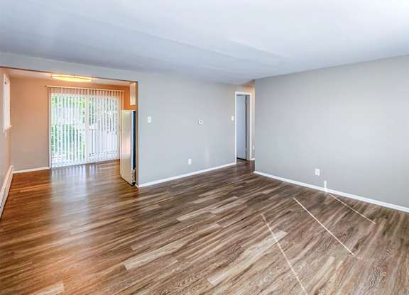 A room with wooden flooring and white walls.