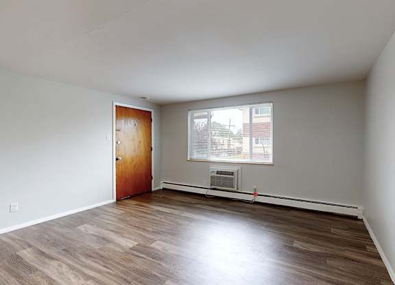 Empty room with wooden floors and white walls.
