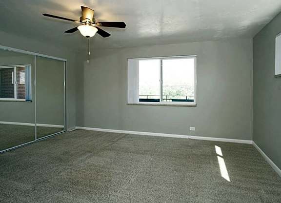 A room with a ceiling fan and a window.