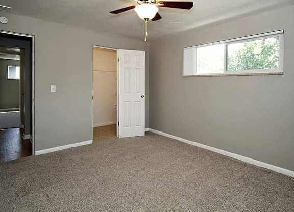 A room with a ceiling fan and a window.