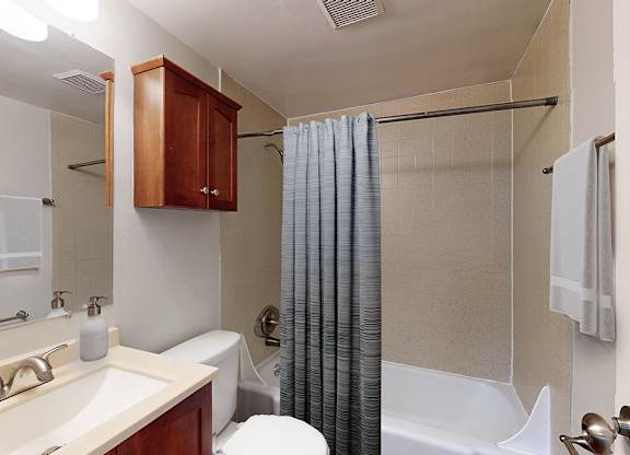 A bathroom with a white tub and a white toilet.