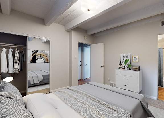 A bedroom with a large bed and a mirror on the wall.