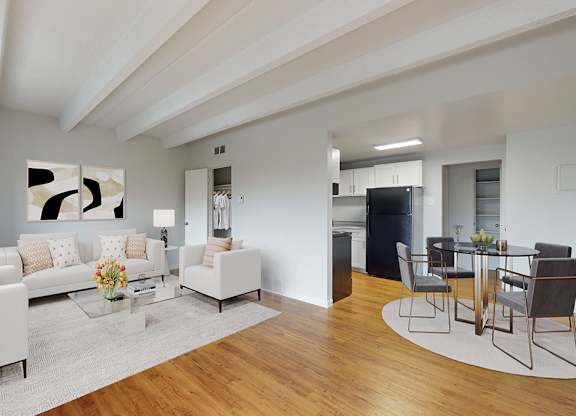A modern living room with white furniture and a wooden floor.