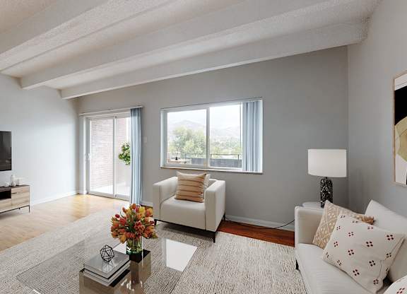 A living room with a white couch, a coffee table, and a flat screen TV.