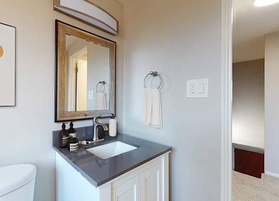 A bathroom with a white tub and a mirror above a sink.