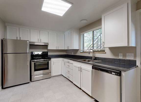 A modern kitchen with stainless steel appliances and white cabinets.