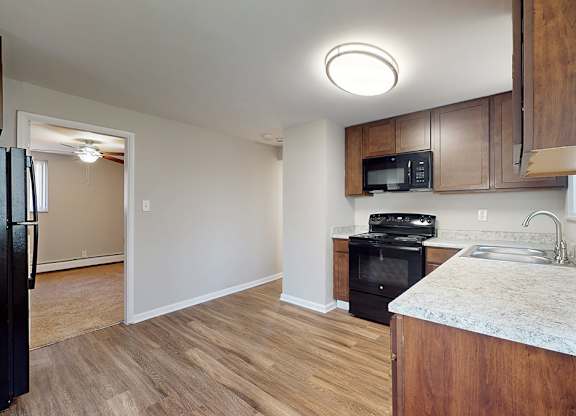 A kitchen with a black oven and microwave built into the cabinetry.