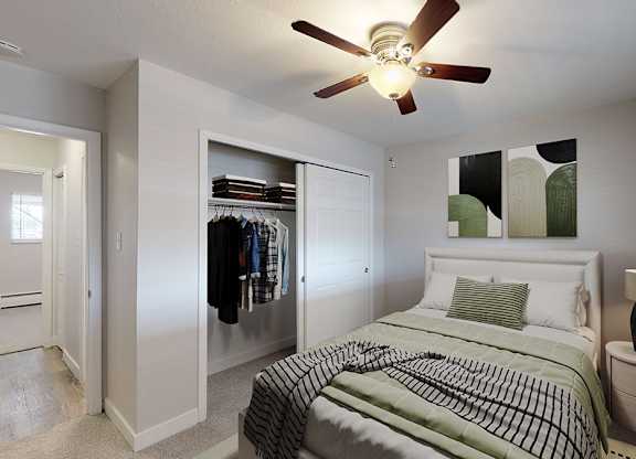 A bedroom with a bed, a ceiling fan, and a nightstand.