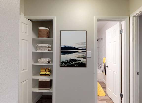 A bathroom with a white door and a picture of a beach on the wall.