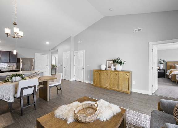 A modern living room with a dining area and kitchen in the background.