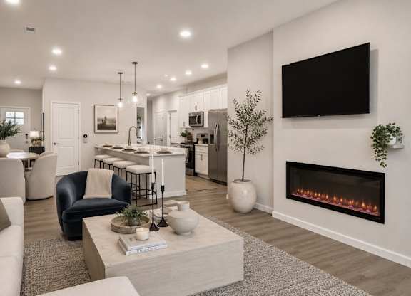 A modern living room with a fireplace and a flat screen TV mounted on the wall.