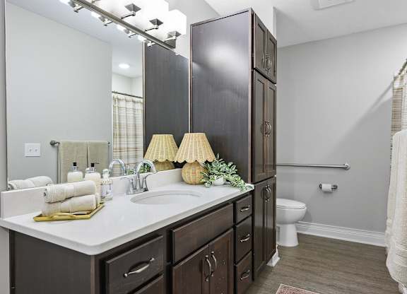 A bathroom with a white counter top and a white sink.