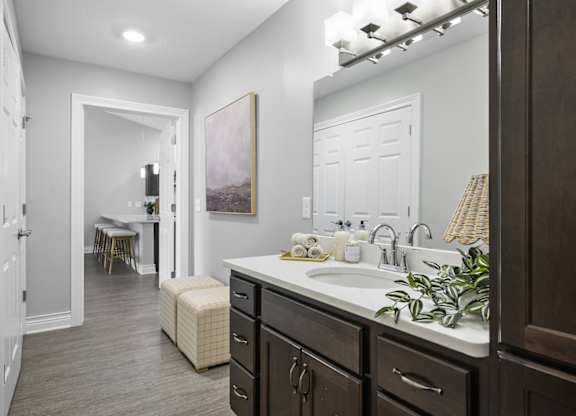 A bathroom with a white sink and a mirror above it.
