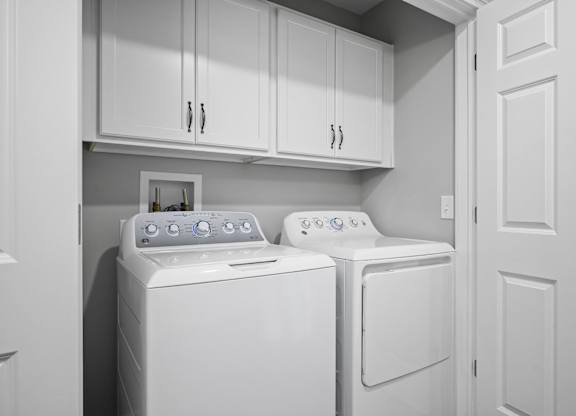 A white washing machine and dryer in a laundry room.