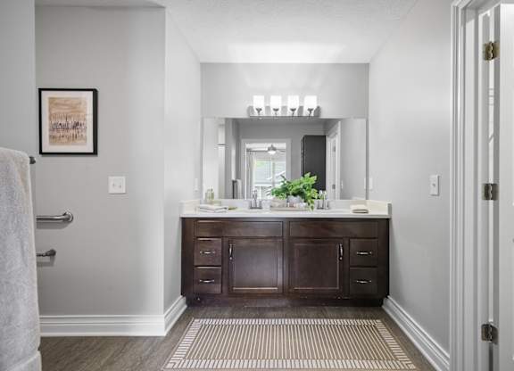 A bathroom with a vanity and a mirror above it.