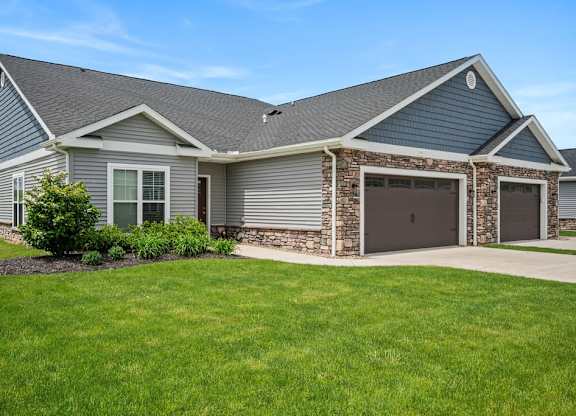 A house with a grey roof and a stone pillar.
