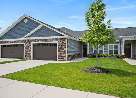 A house with a grey roof and a tree in front.