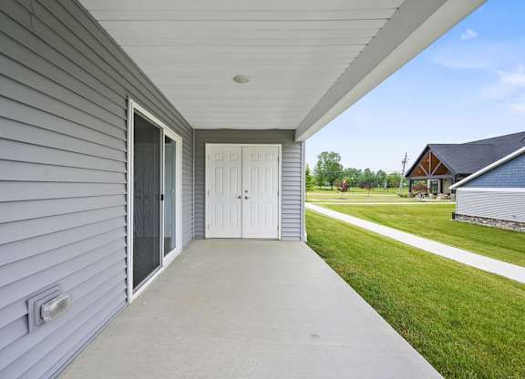 A grey house with a white door and a window.