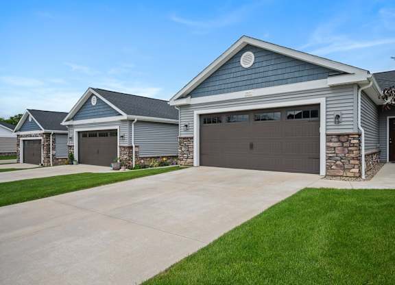 A house with a grey garage door is shown.