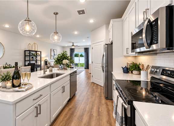 A modern kitchen with white cabinets and a black stove top.