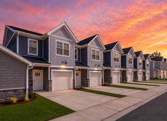 A row of houses with garages and driveways.