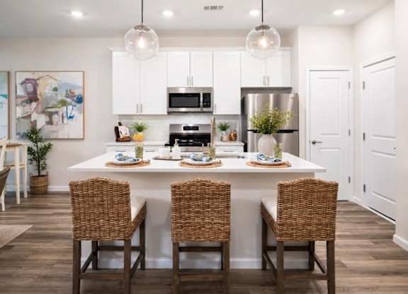 A modern dining room with a white table and chairs.