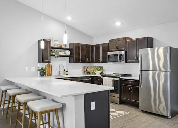 A modern kitchen with a white island and stainless steel appliances.