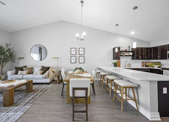 A modern kitchen and living room with a dining table and chairs.