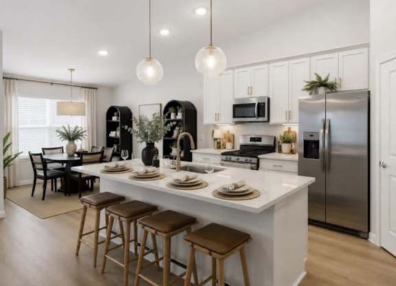 A modern kitchen with a white countertop and stainless steel appliances.