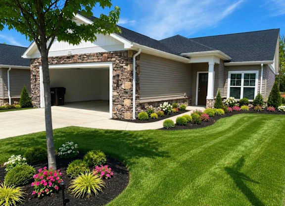 A house with a stone pillar and a tree in front.