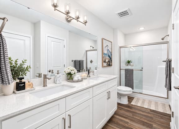 A white bathroom with a glass shower stall and a towel rack.