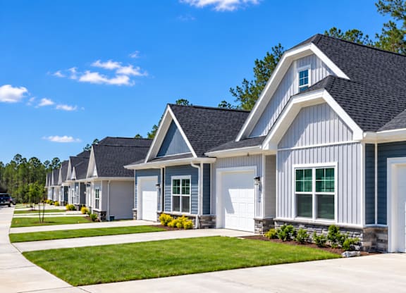 A row of houses with white garage doors.