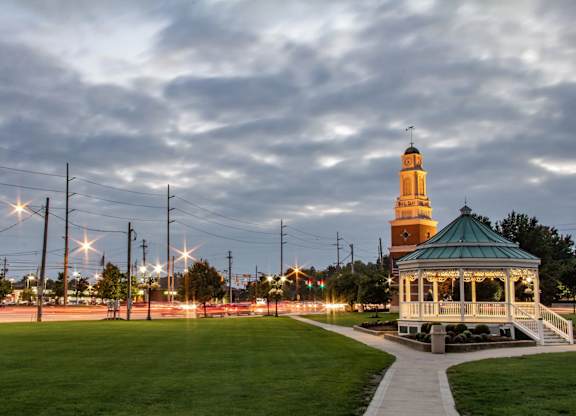 A gazebo is situated in the middle of a grassy field.