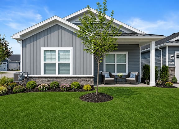 A house with a grey exterior and a tree in the front yard.