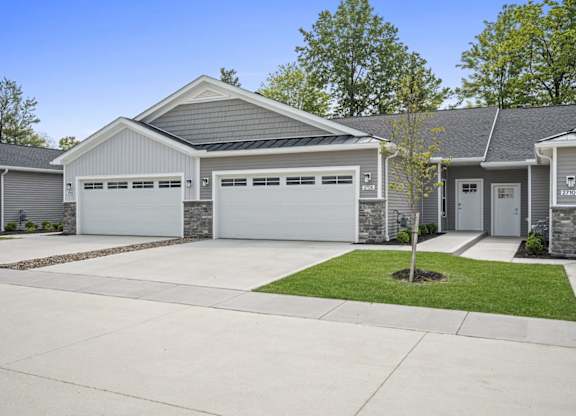 A house with a grey roof and white garage doors.