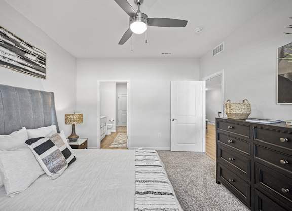 A bedroom with a large bed and a ceiling fan.