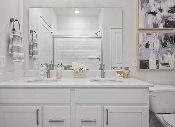 A bathroom with two sinks and a toilet.