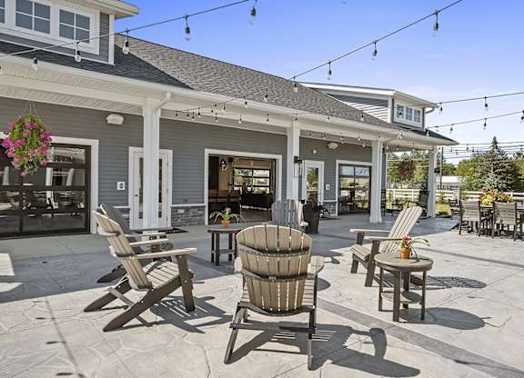 A patio with chairs and a table is set up outside a house.