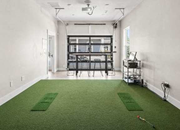 A room with a green carpet and a long table with chairs.
