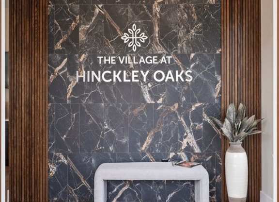 A modern lobby with a marble wall and a white bench.