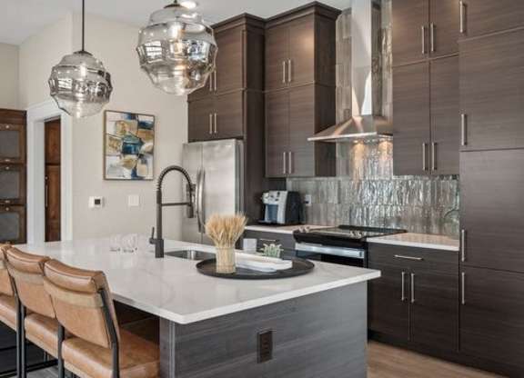 A modern kitchen with dark brown cabinets and a white countertop.