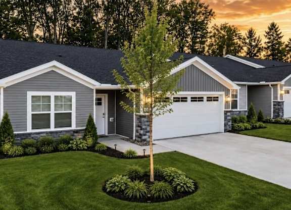 A house with a grey exterior and a white garage door.