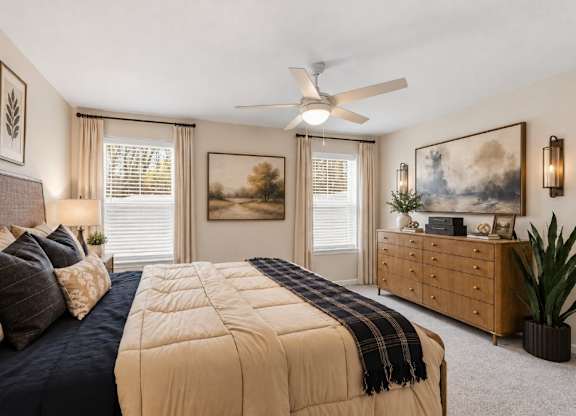 A bedroom with a large bed and a ceiling fan.