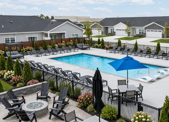 A pool surrounded by black chairs and umbrellas.
