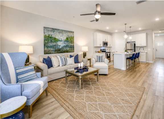 A living room with a sofa, chairs, and a rug.