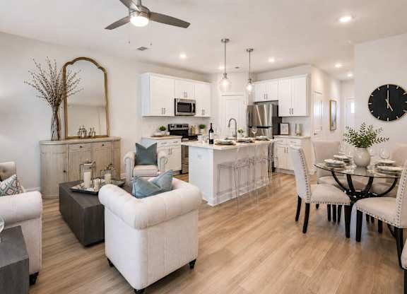 A modern living room with a kitchen in the background.
