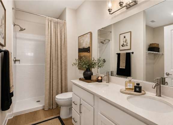 A bathroom with a white toilet, sink, and shower.